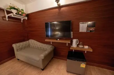 a living room with a couch and a television at @42 Residence in Bangkok