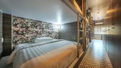 a bedroom with a bed and a floral wall at Happy Station Bangkok in Bangkok