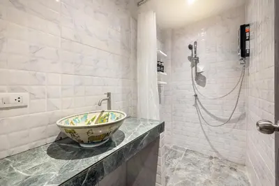 a bathroom with a bowl sink and a shower at Happy Station Bangkok in Bangkok