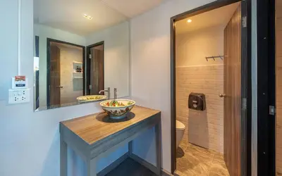 a bathroom with a sink and a toilet and a mirror at Happy Station Bangkok in Bangkok