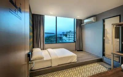 a bedroom with a bed and a large window at Happy Station Bangkok in Bangkok