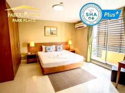 a hotel room with a bed and a sign at Paholyothin Park Place in Bangkok