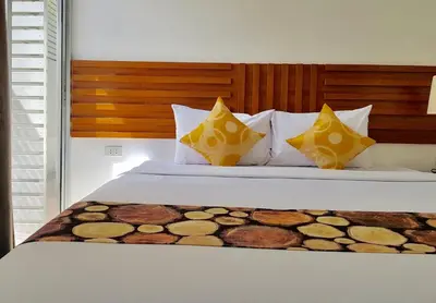 a bedroom with a bed with yellow and white pillows at Paholyothin Park Place in Bangkok