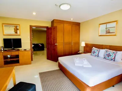 a bedroom with a large bed and a television at Paholyothin Park Place in Bangkok