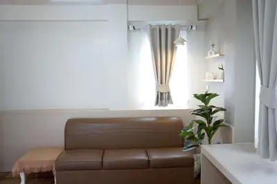 a living room with a brown couch and a window at ปลื้มจิต อพาร์ทเม้น บางใหญ่ in Nonthaburi