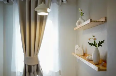 a room with a window with a curtain and a lamp at ปลื้มจิต อพาร์ทเม้น บางใหญ่ in Nonthaburi