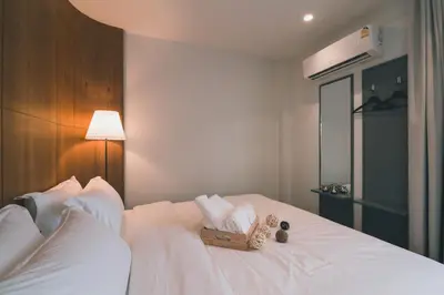 a white bed with a box of towels on it at 41Cafetel in Bangkok