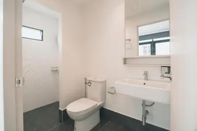 a white bathroom with a toilet and a sink at 41Cafetel in Bangkok