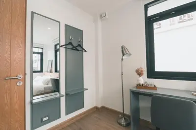 a bedroom with a mirror and a desk with a bed at 41Cafetel in Bangkok