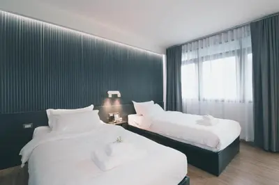 two beds sitting next to each other in a room at 41Cafetel in Bangkok