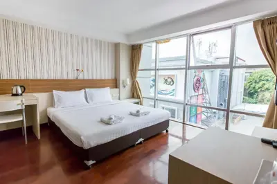 a hotel room with a bed and a large window at Snooze Hotel Thonglor Bangkok in Bangkok
