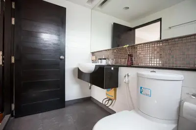 a bathroom with a toilet and a sink and a mirror at Snooze Hotel Thonglor Bangkok in Bangkok