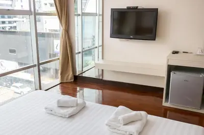 a hotel room with a bed with towels on it at Snooze Hotel Thonglor Bangkok in Bangkok