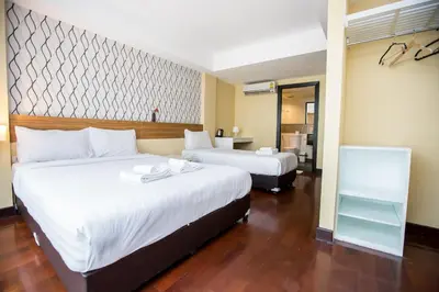 a hotel room with two beds and a bathroom at Snooze Hotel Thonglor Bangkok in Bangkok