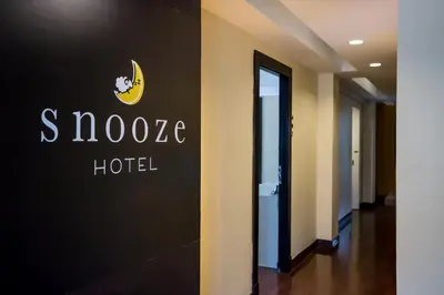 a hotel sign on the wall of a hallway at Snooze Hotel Thonglor Bangkok in Bangkok