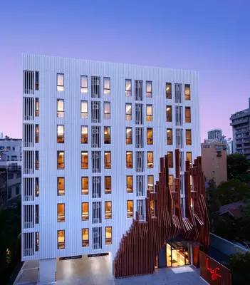a white building with a sculpture in front of it at lyf Sukhumvit 8 Bangkok in Bangkok