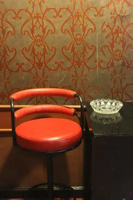 a red chair sitting in front of a wall at Million Mansion in Bangkok