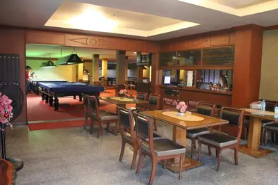 a restaurant with tables and chairs and a pool table at Million Mansion in Bangkok