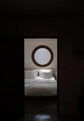 a bedroom with a bed with a round mirror above it at Marlowe-Tony's home in Bangkok