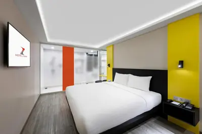 a bedroom with a white bed and colorful walls at Hotel Z zpaze in Bangkok