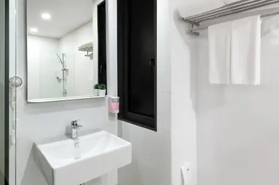 a white bathroom with a sink and a mirror at Hotel Z zpaze in Bangkok