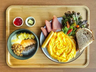 a tray with a plate of food on a table at The Cotton Saladaeng Hotel in Bangkok