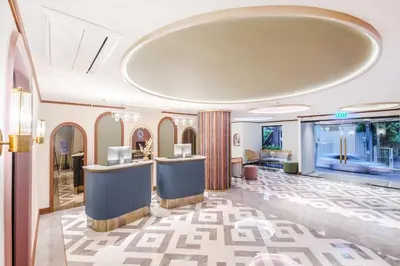 a hotel lobby with a reception desk and a large window at The Cotton Saladaeng Hotel in Bangkok