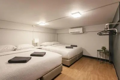 a hotel room with two beds with towels on them at S1 Large Duplex Silom 3 Beds, Full Kitchen WIFI in Bangkok