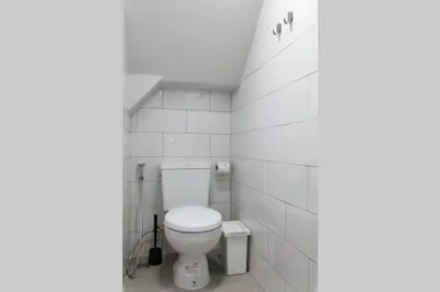 a bathroom with a toilet in a white tiled wall at S1 Large Duplex Silom 3 Beds, Full Kitchen WIFI in Bangkok