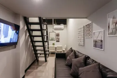 a living room with a couch and a television at S1 Large Duplex Silom 3 Beds, Full Kitchen WIFI in Bangkok
