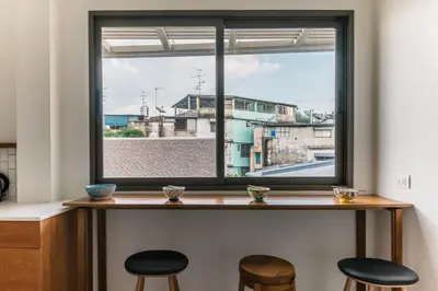 a window with two stools in front of a table with a view at APT476 in Bangkok