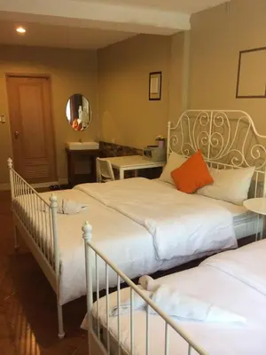 a bedroom with two beds and a mirror at VX The Fifty in Bangkok