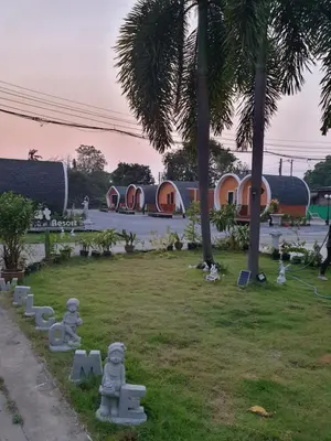 a park with concrete statues in front of a building at Tiny hut resort in Bangkok