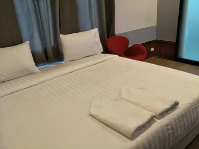 a bed with two towels sitting on top of it at Tiny hut resort in Bangkok