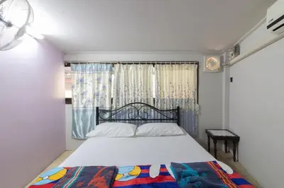 a bedroom with a bed and a window at 7 Holder Guesthouse in Bangkok