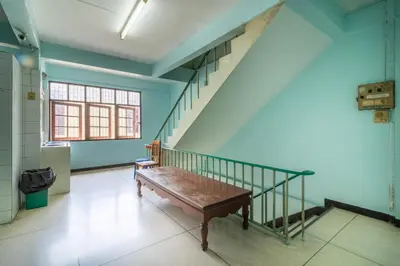 a bench in a room with a stair case at 7 Holder Guesthouse in Bangkok