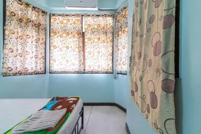 a room with two windows with flowers on the curtains at 7 Holder Guesthouse in Bangkok