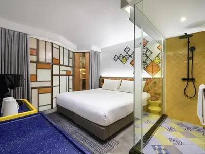 a bedroom with a bed and a glass wall at ibis Styles Bangkok Silom in Bangkok