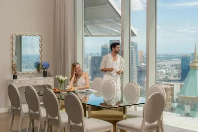 a man and woman standing in a dining room with a table at Magnolias Ratchadamri Boulevard Serviced Residences in Bangkok