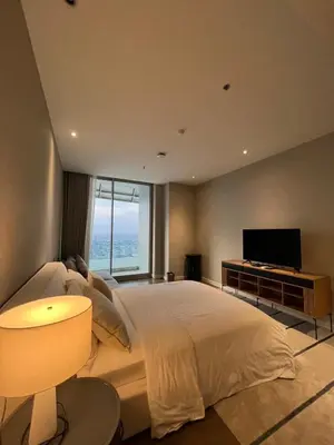 a bedroom with a large bed and a flat screen tv at Magnolias Ratchadamri Boulevard Serviced Residences in Bangkok