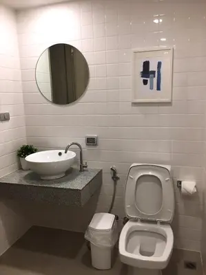 a bathroom with a sink and a toilet and a mirror at Blu 395 in Bangkok