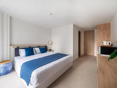 a bedroom with a large bed with blue pillows at Blu 395 in Bangkok