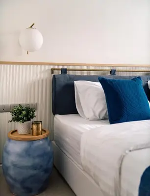a bedroom with a bed with blue and white pillows at Blu 395 in Bangkok