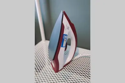 a red and white iron sitting on a bed at S2 Silom Large room 4-6 guests Full kitchen WIFI in Bangkok