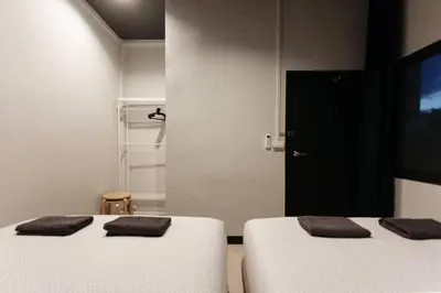 two beds in a room with two brown pillows on them at S3 Silom26 · S3 Silom central, large room, full kitchen, WIFI, in Bangkok