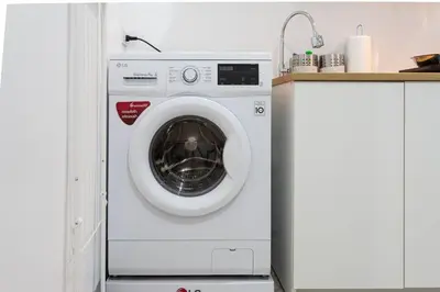 a white washing machine in a kitchen next to a counter at P1 Silom Pan large room full kitchen WIFI 4-6pax in Bangkok