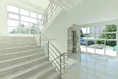 a staircase in a house with white walls and windows at Parvena Ratchada in Bangkok
