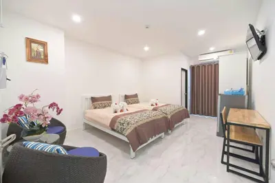 a bedroom with a bed and a table and chairs at Parvena Ratchada in Bangkok