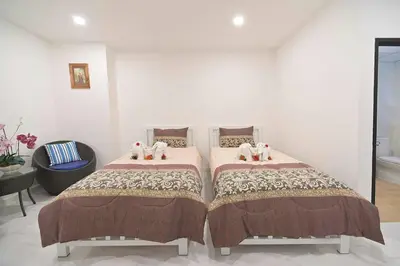 a bedroom with two beds with stuffed animals on them at Parvena Ratchada in Bangkok