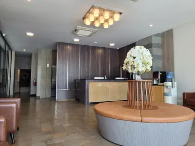 a lobby with a table with a vase of flowers at Marsi Hotel @ Bangchak in Bangkok